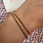 twee gouden armbanden aan de pols
